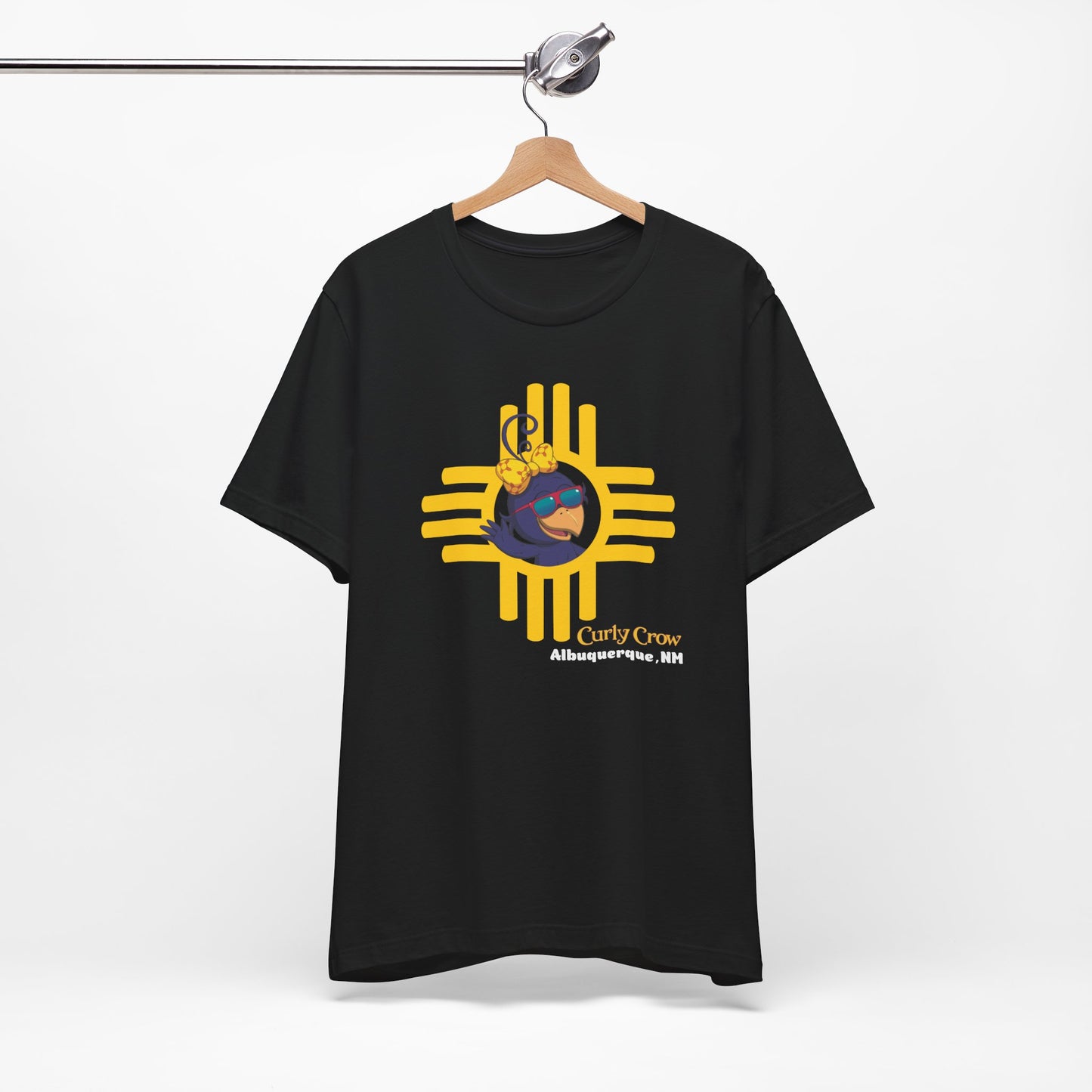 Black t-shirt with a yellow and blue graphic design on a hanger against a white background