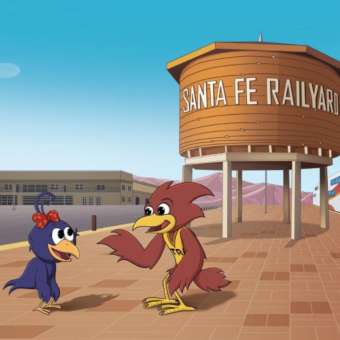 Curly Crow and Trax in front of a Santa Fe Railyard water tower.