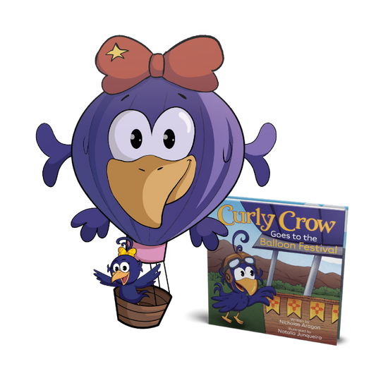 A colorful Balloon Fiesta Pillow shaped like a crow-themed hot air balloon, featuring Curly Crow riding in the basket, displayed next to the kids book, Curly Crow Goes to the Balloon Festival.